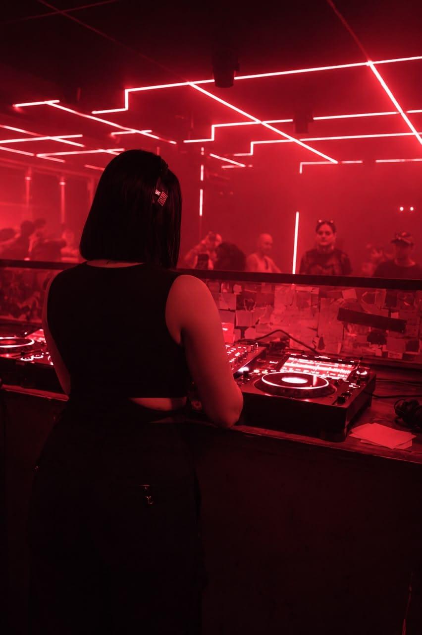 5OGOL seen from behind, facing a crowd under red neon lines