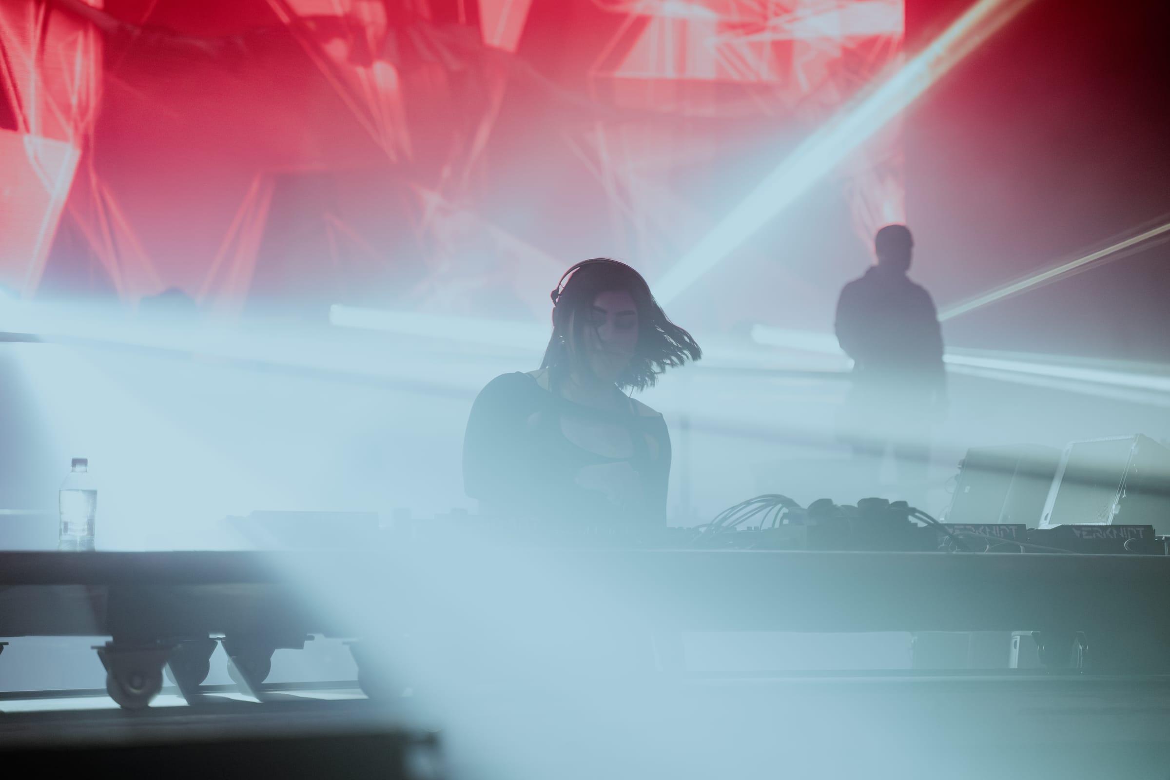 5OGOL behind the booth, silhouetted against lasers and haze